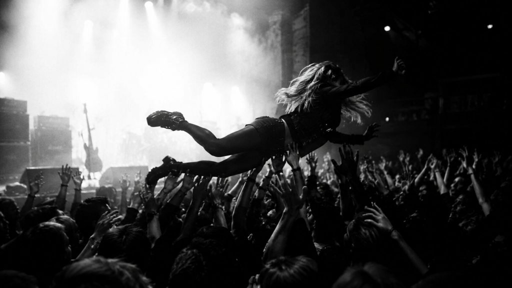 Black-and-white cinematic stage-dive image symbolizing creative risk and reinvention in Charli xcx’s “Rock Music.”